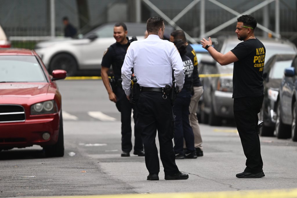 Police stand in the streets, near the scene of the fatal shooting.