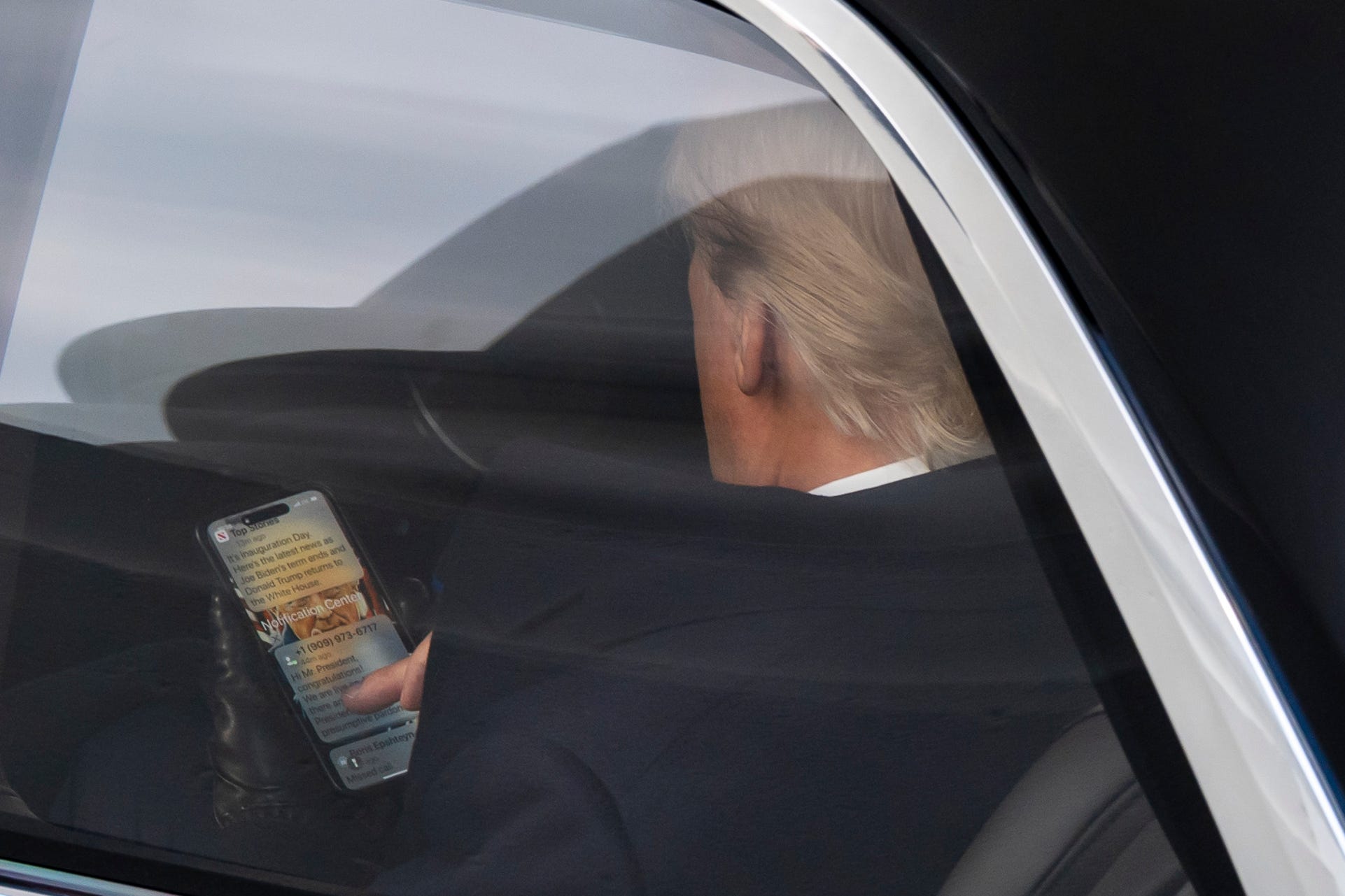 Trump is seen looking at texts on his way to his second inauguration