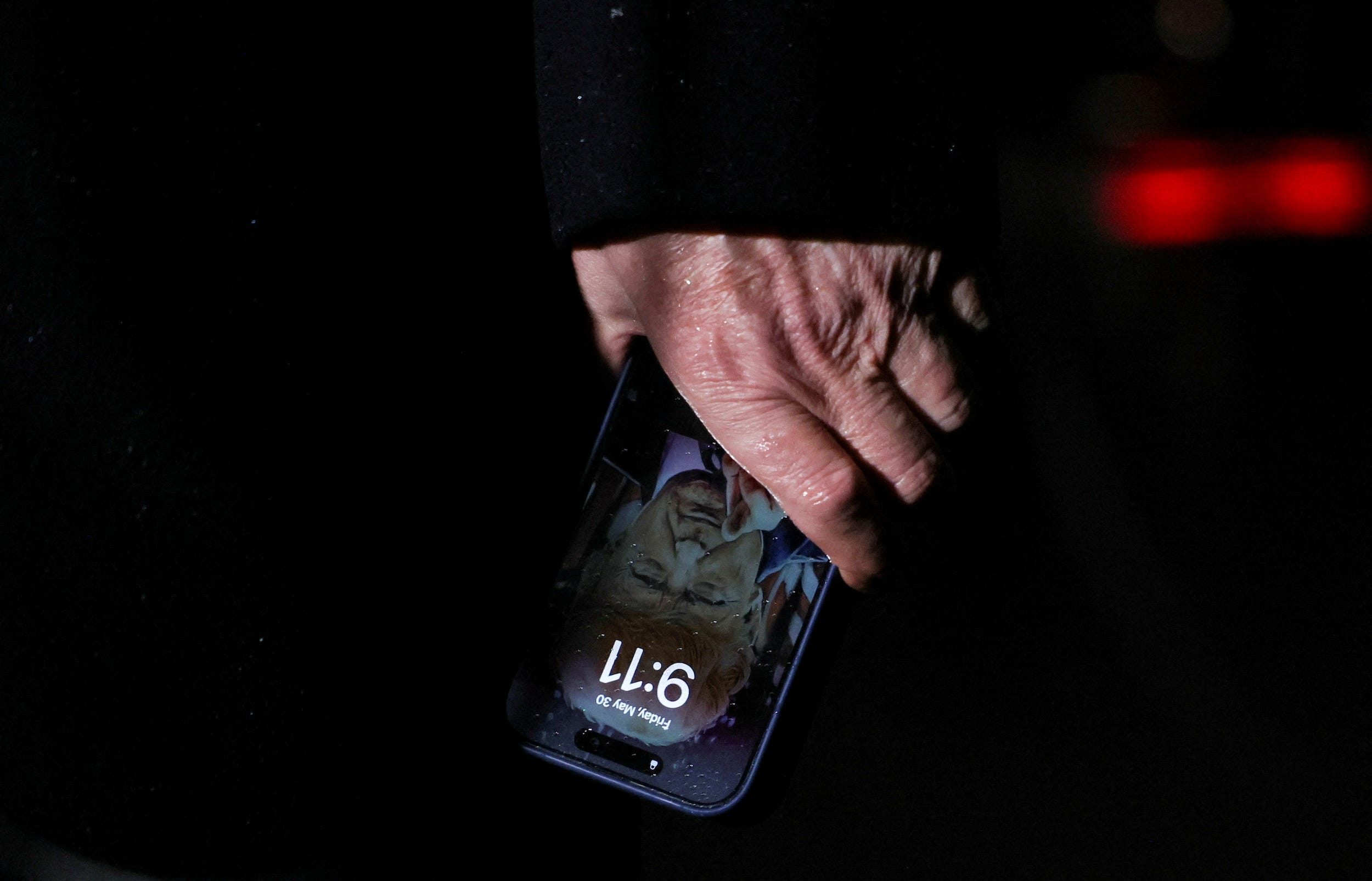 Trump's lockscreen can be seen as he holds his iPhone