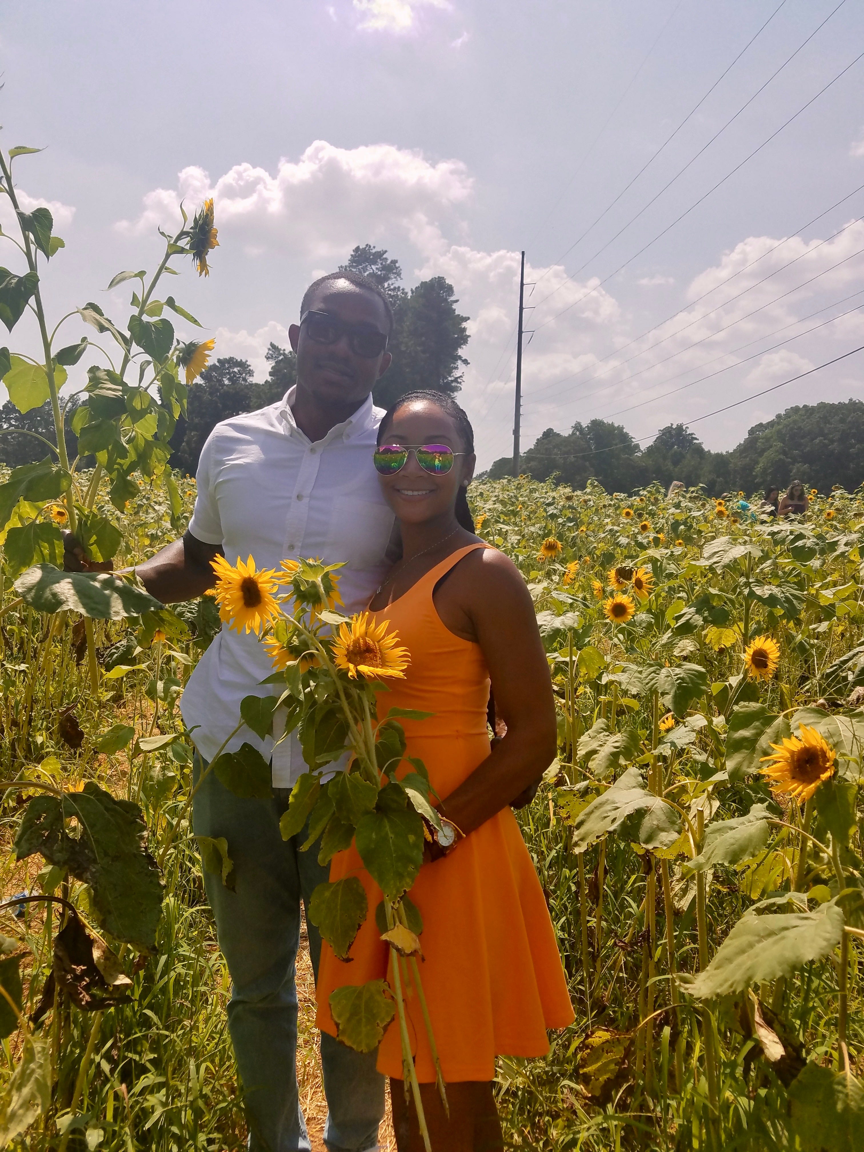 Jenna Scott and her husband in a field of sunflowers.