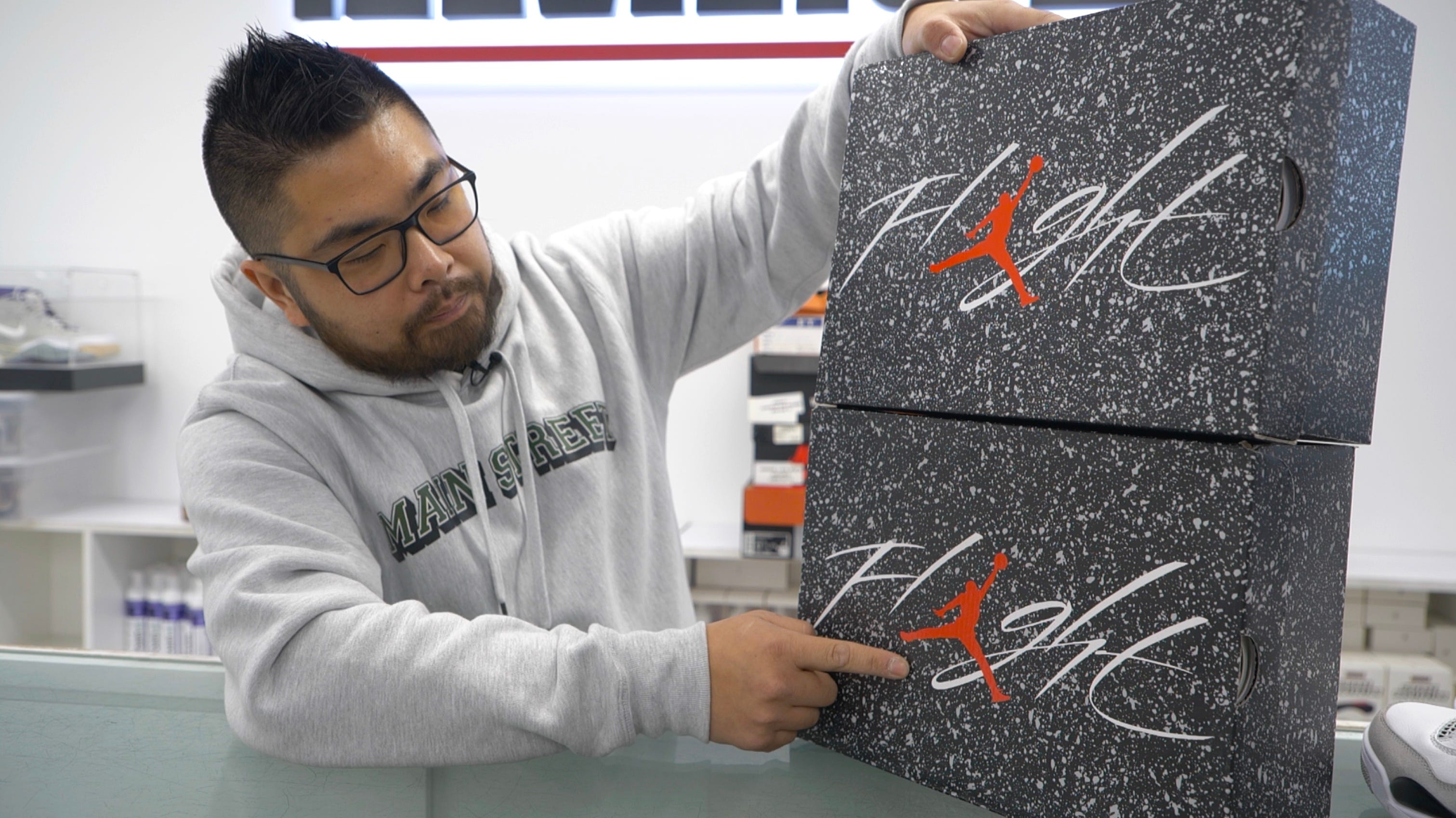 Shu Cheng authenticating one real Nike box and one fake