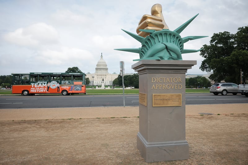 A wide shot of the "Dictator Approved" art installation with the Capitol building in the background.