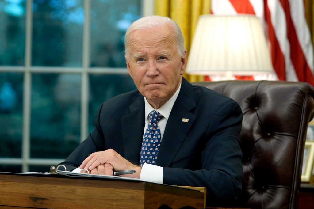 President Joe Biden sitting at his desk in the Oval Office.