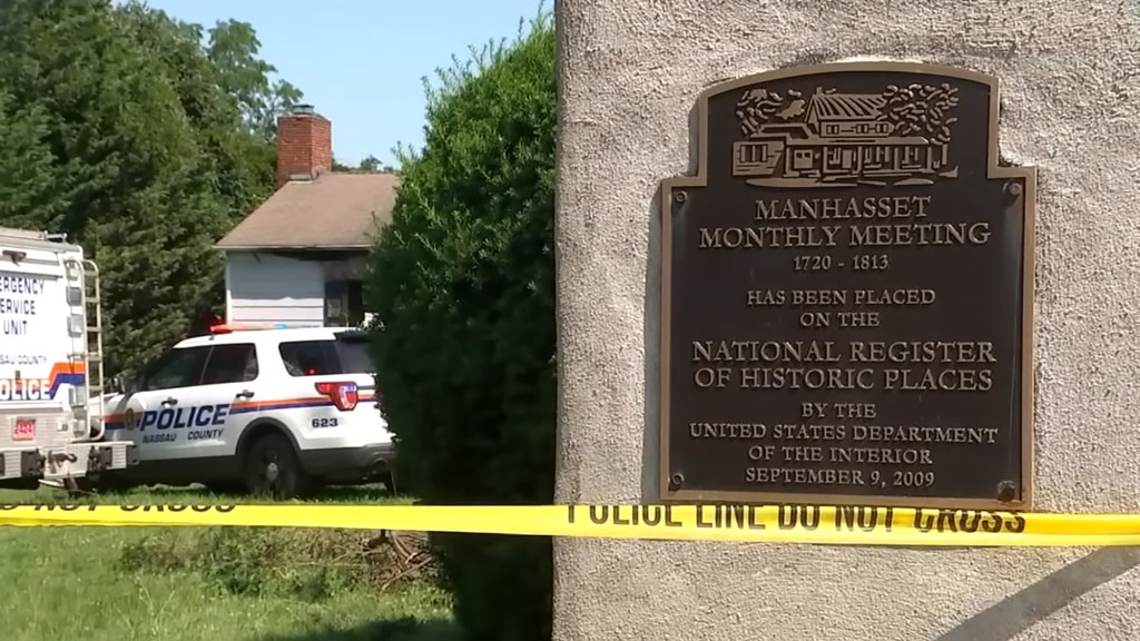 Police car and crime scene tape at historic meeting house.