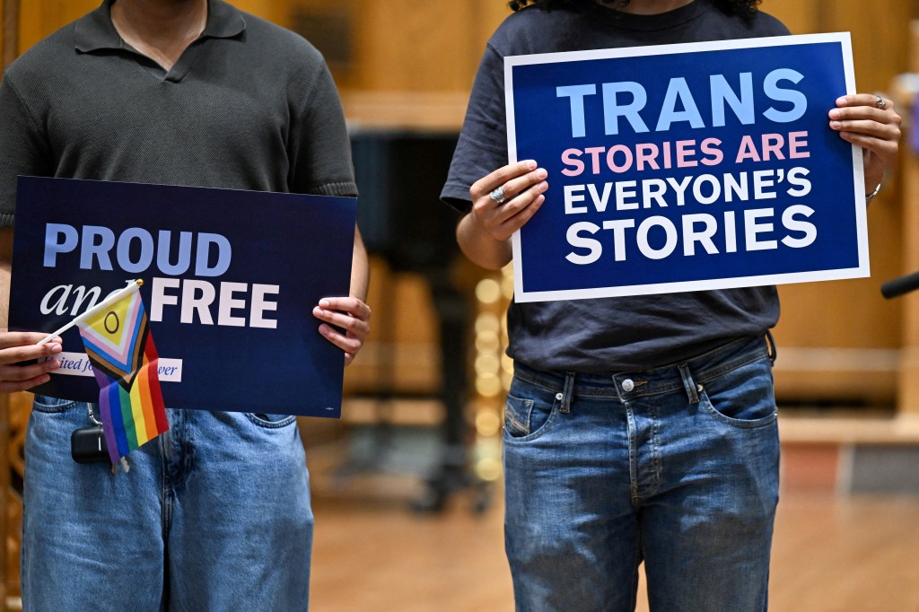 Two people holding signs that read 