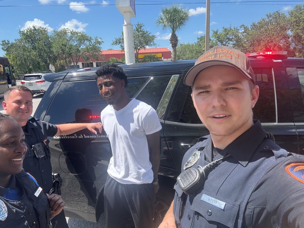 Florida fugitive Aaron Donta Johnson smiles as police officers take a picture after his arrest on June 17, 2025.