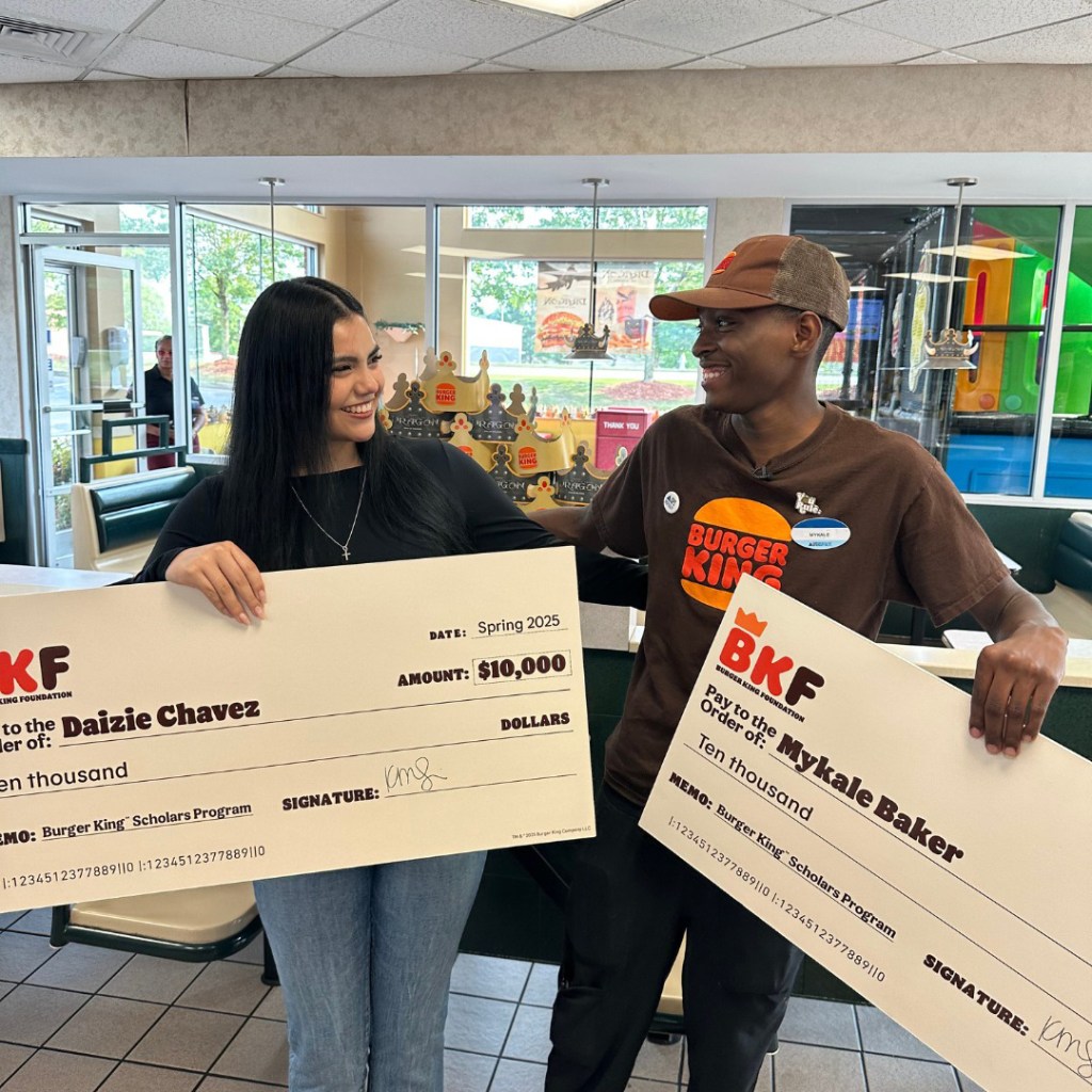Daizie Chavez and Mykale Baker pose with their scholarship checks inside the Dacula Burger King.