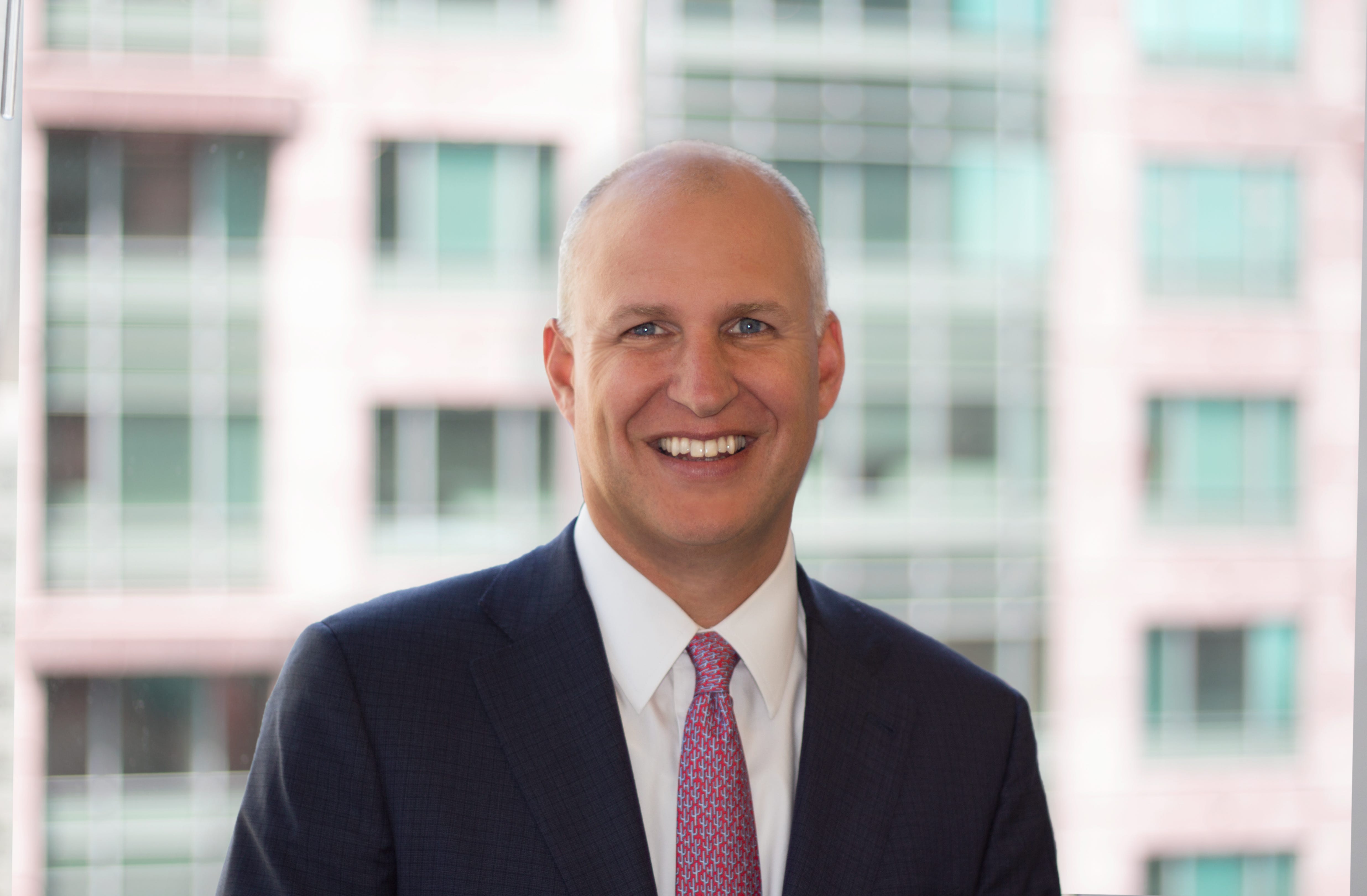 Jeff Akers, Adams Street standing in a suit.