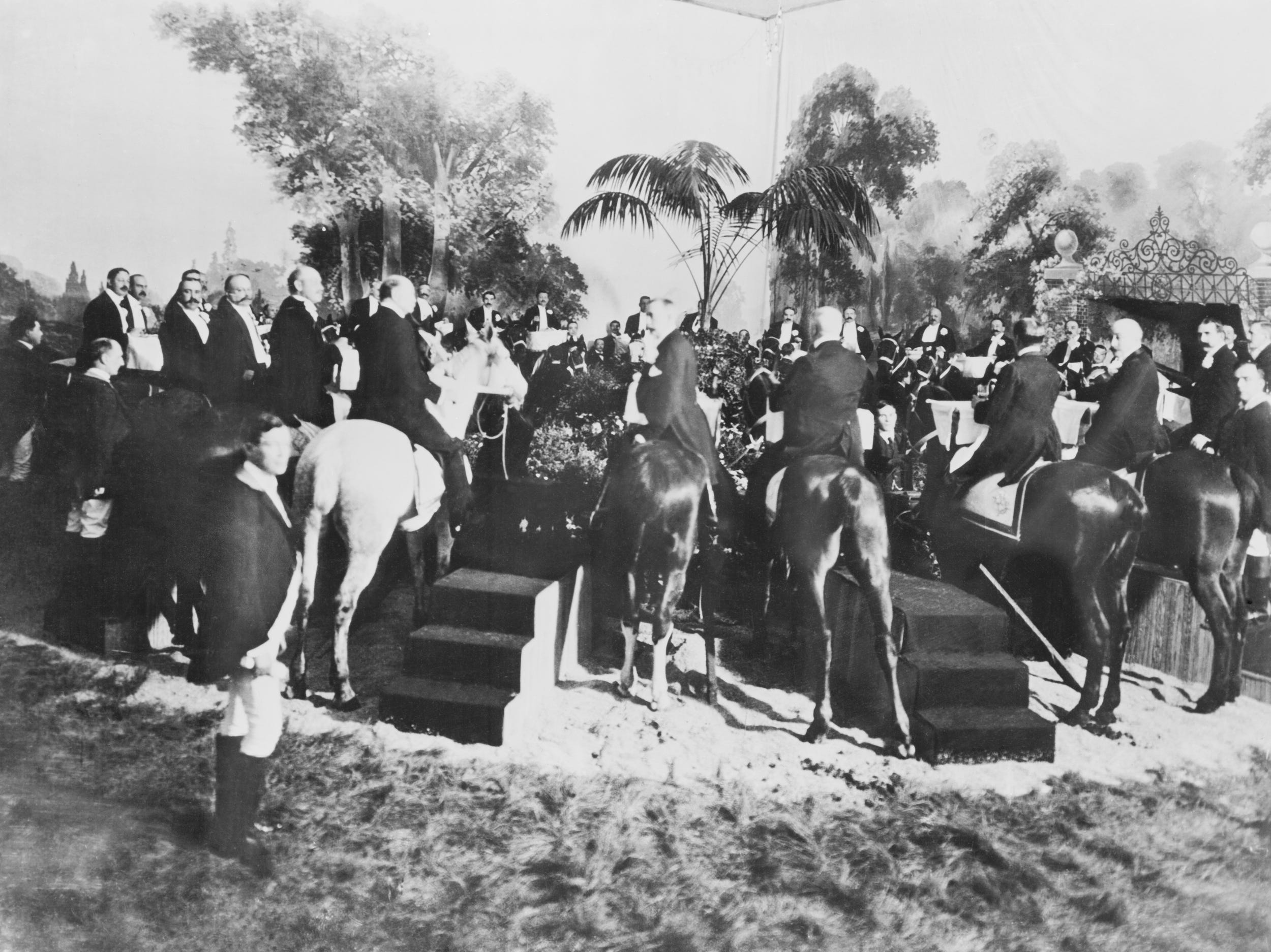 Dozens of guests enjoy a meal sitting on their horses in a New York restaurant in 1903.