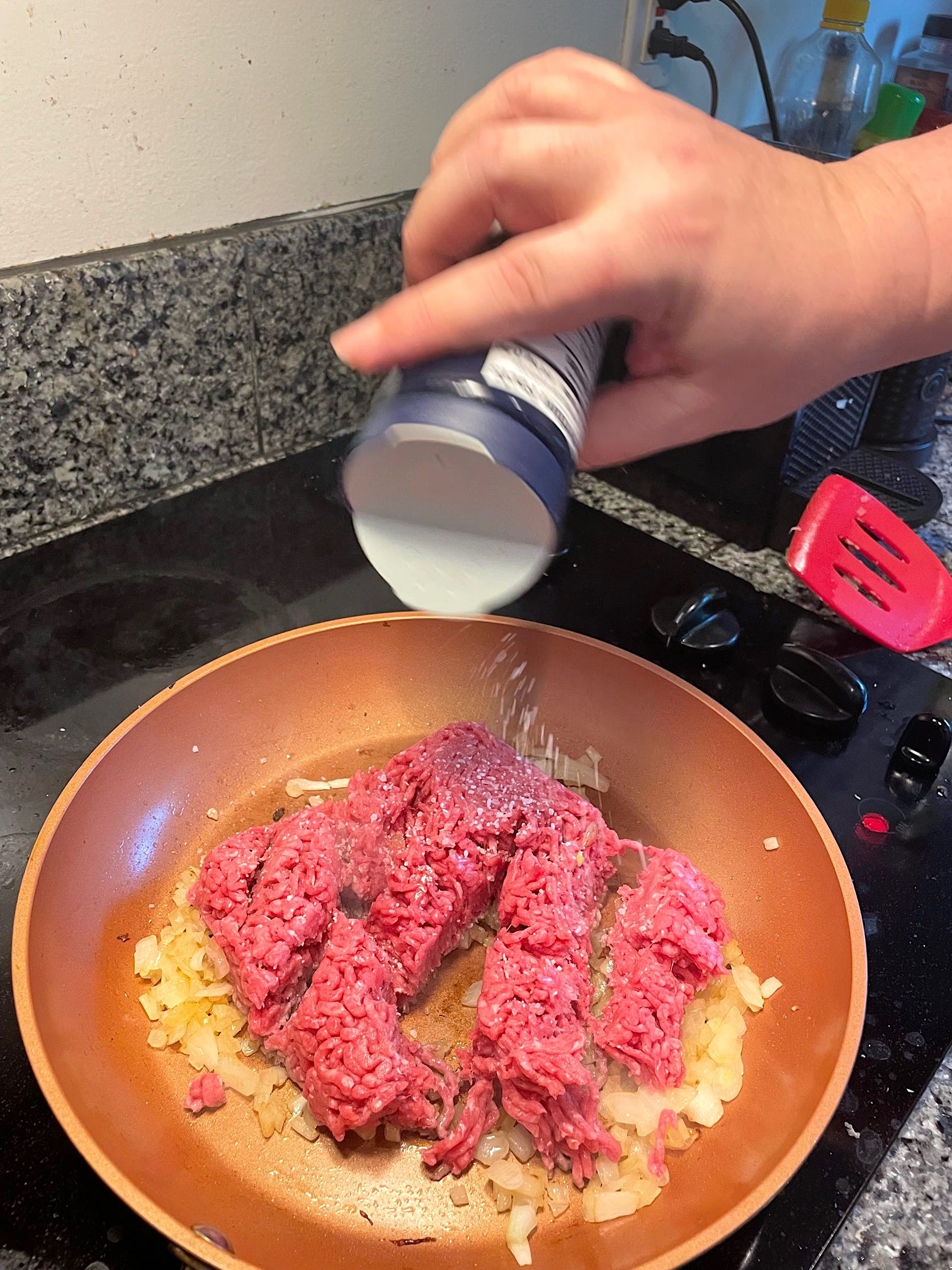 Salting ground beef in pan for yemista