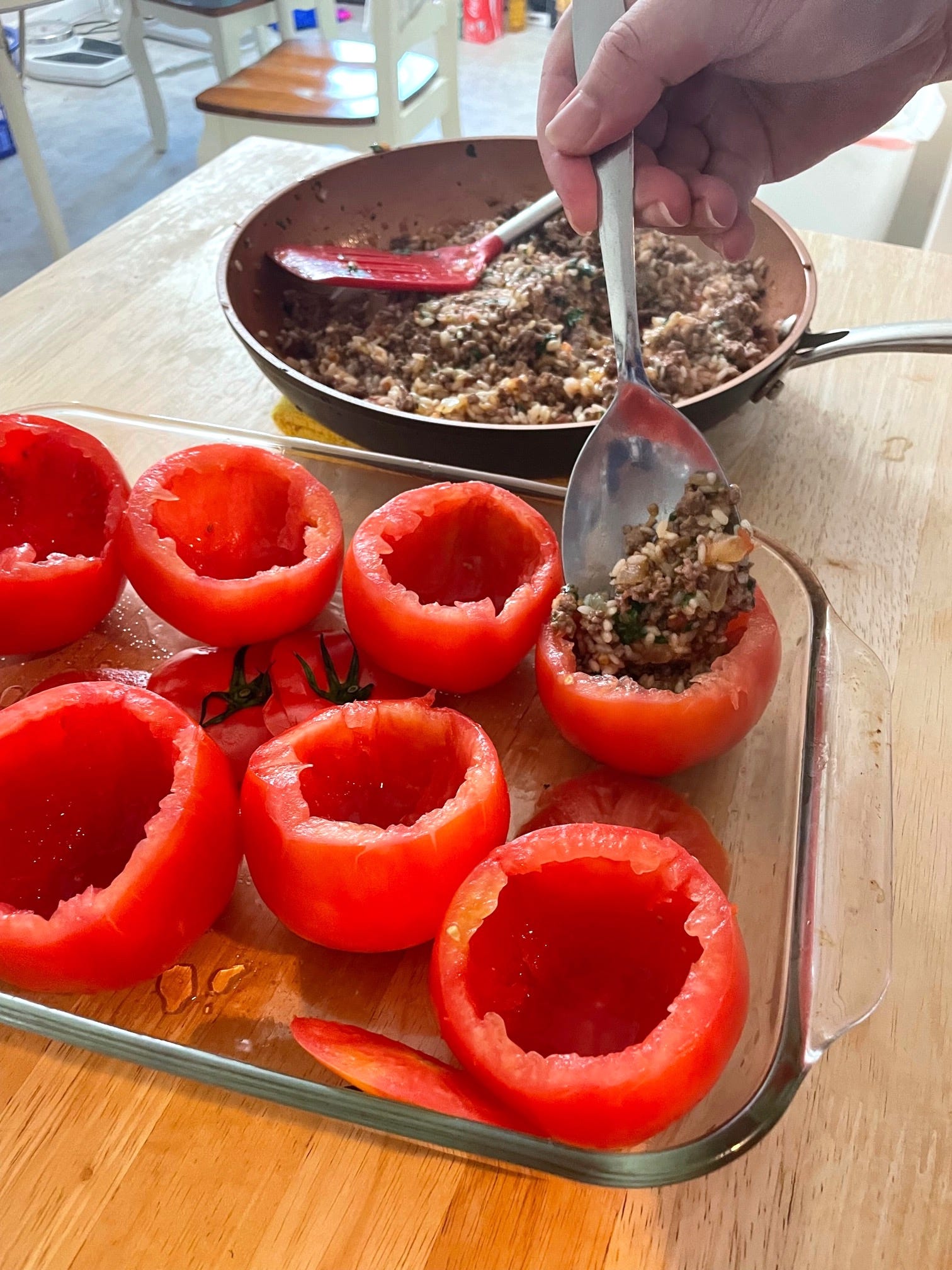 Adding Yemista mixture to tomatoes