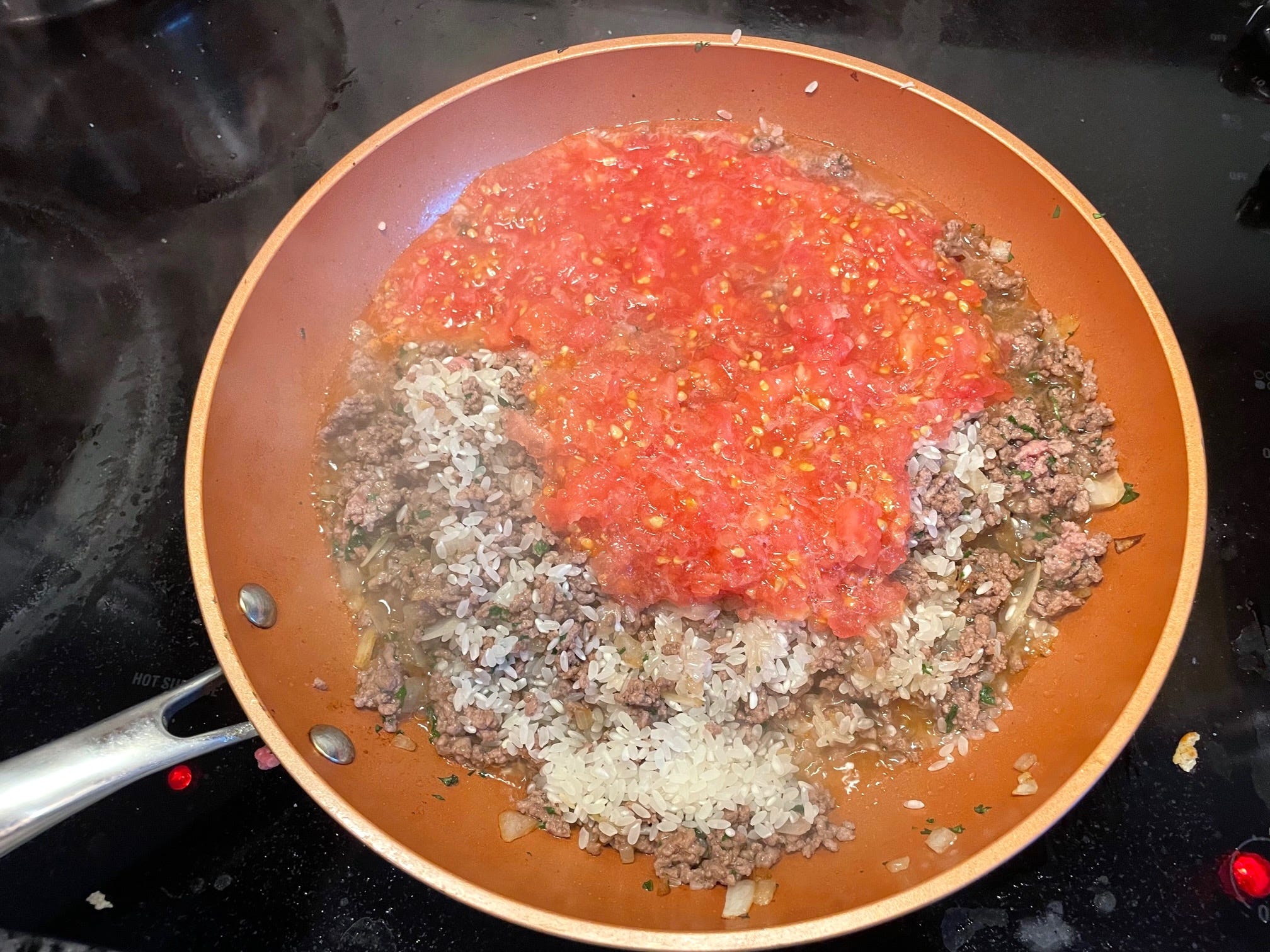 Adding tomato to yemista mixture