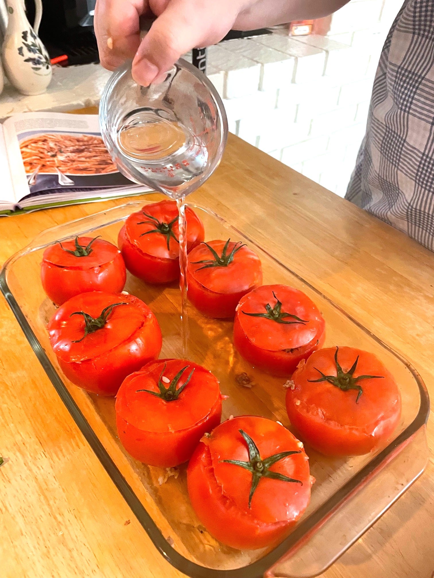 Adding water to tomatoes in pan for yemista