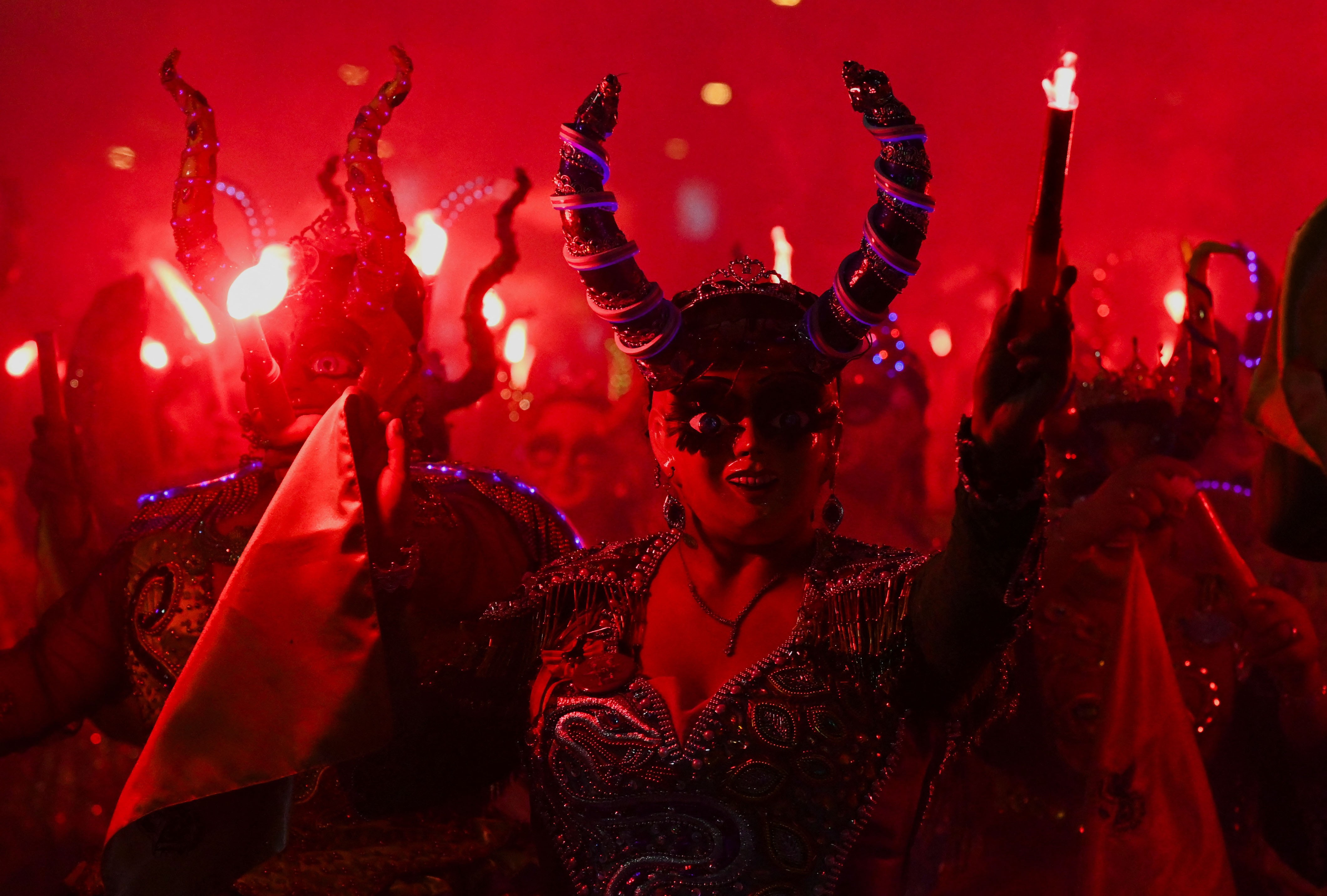 Dancers dressed as devil-angels perform in a parade.