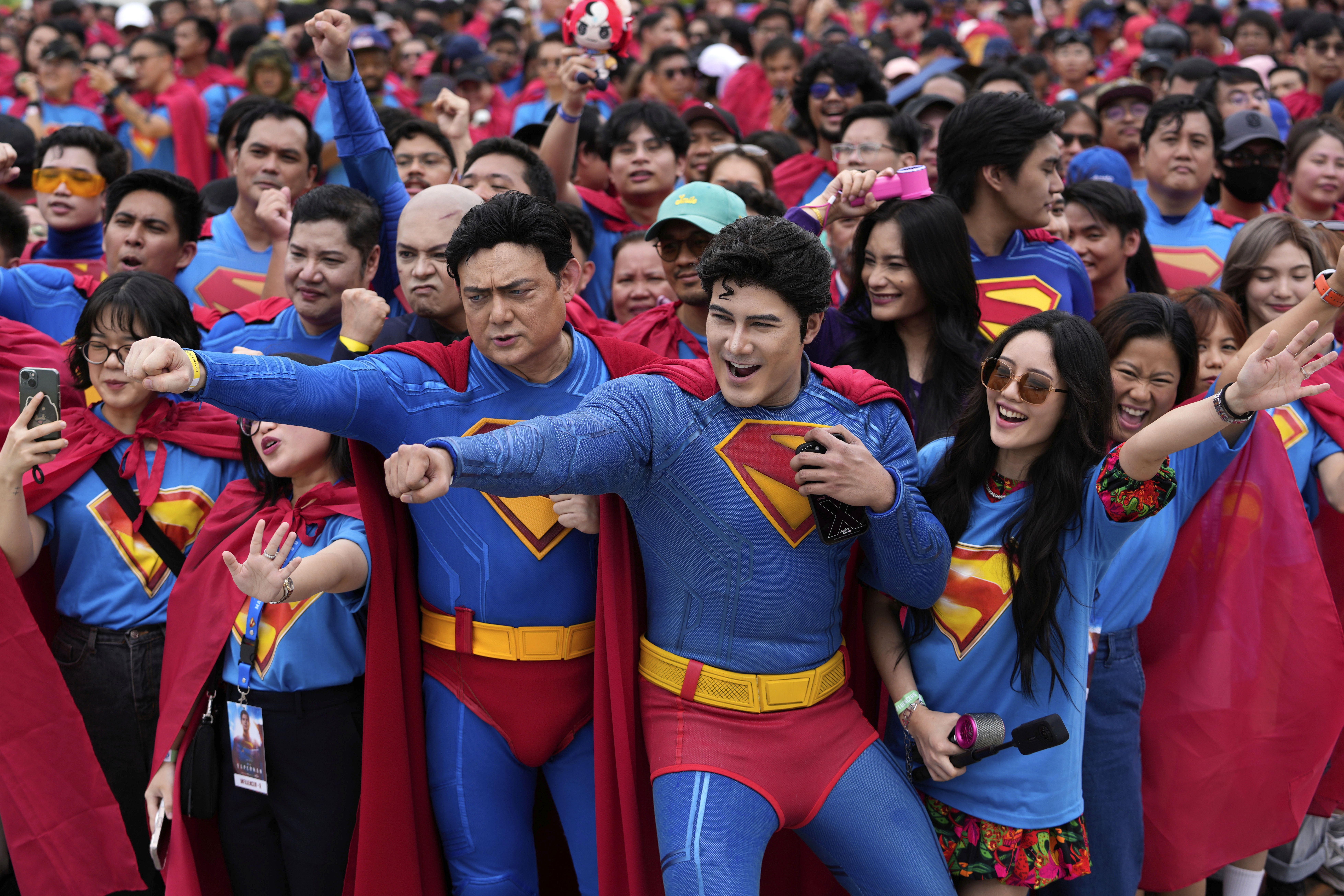 Dozens of people gather together, with many of them wearing Superman costumes.