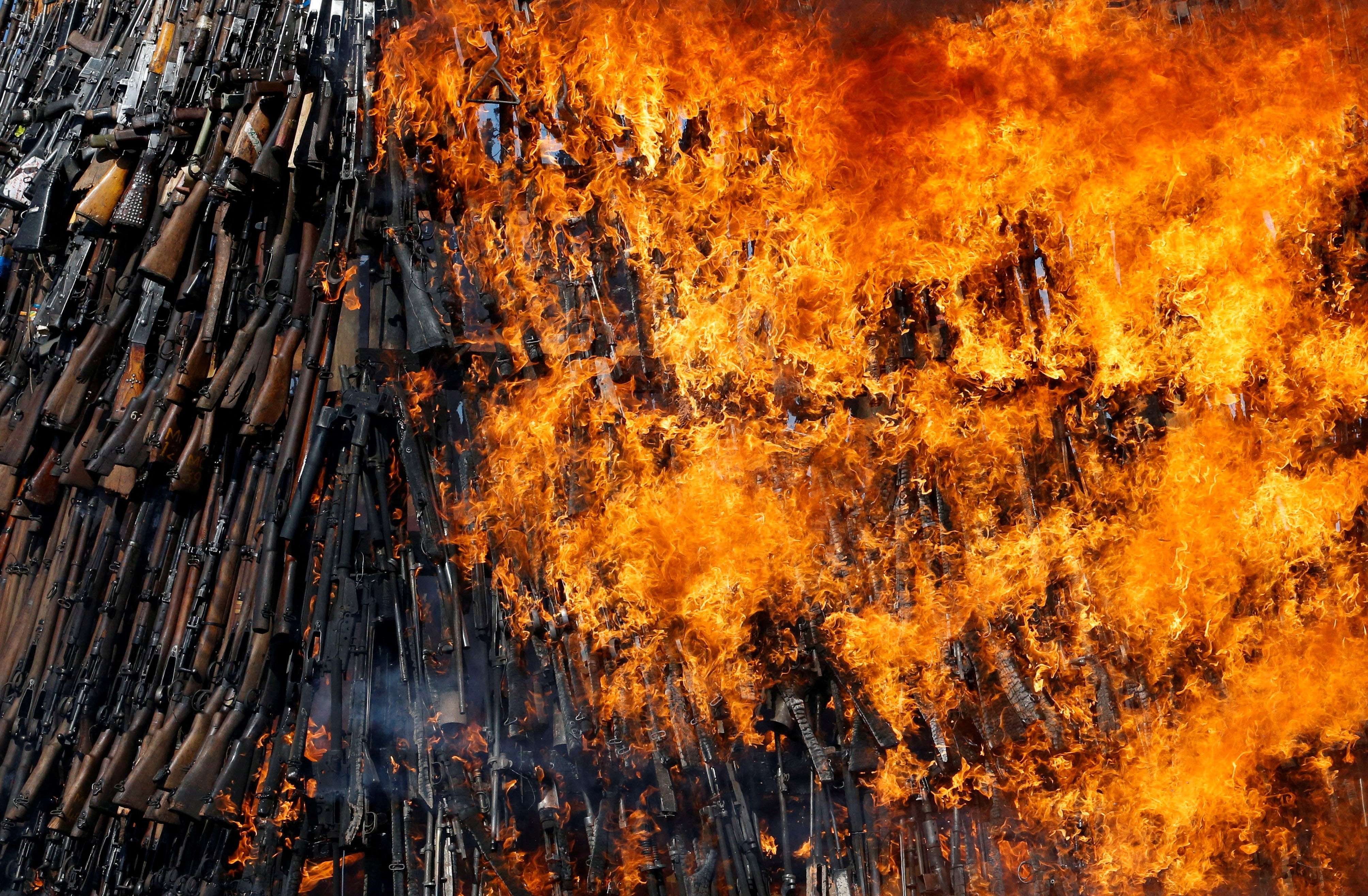 A huge stack of firearms goes up in flames.