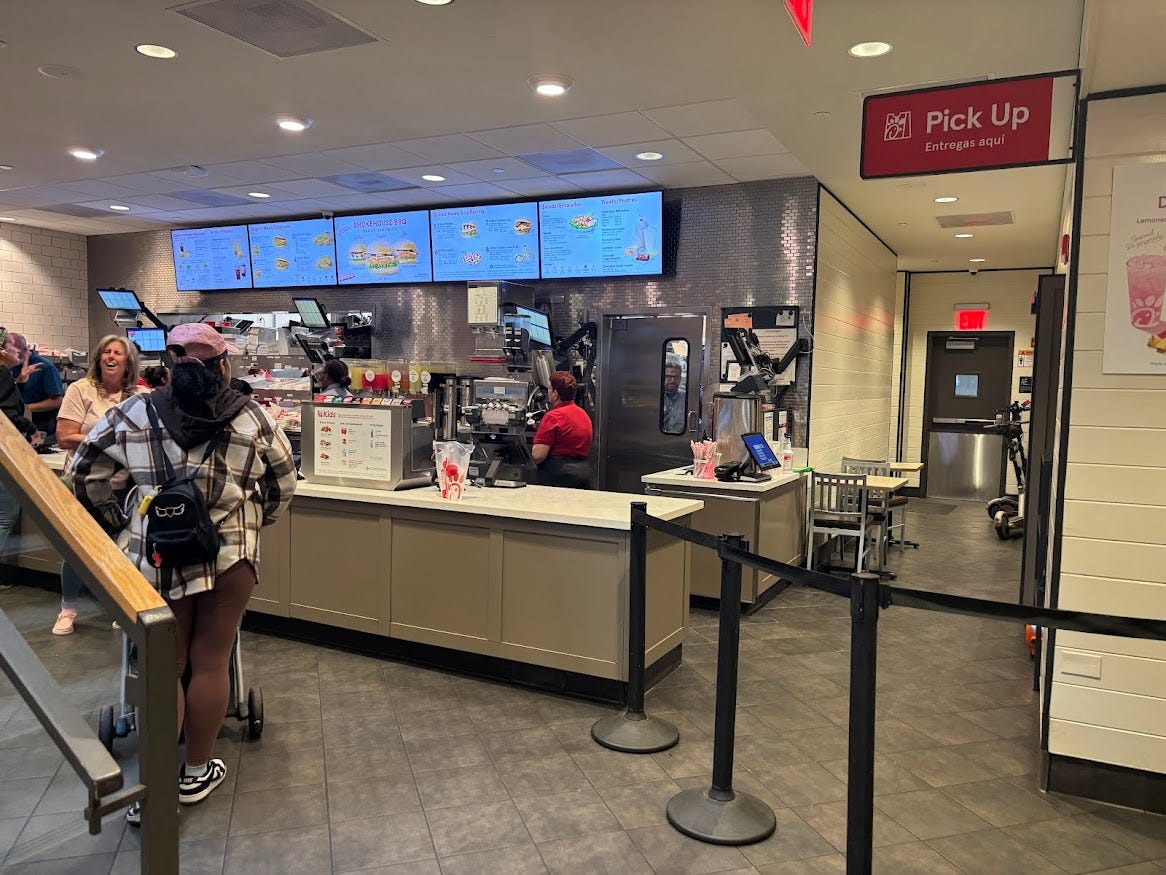 Interior of a Chick-fil-A in NYC: counter, menu screens behind it