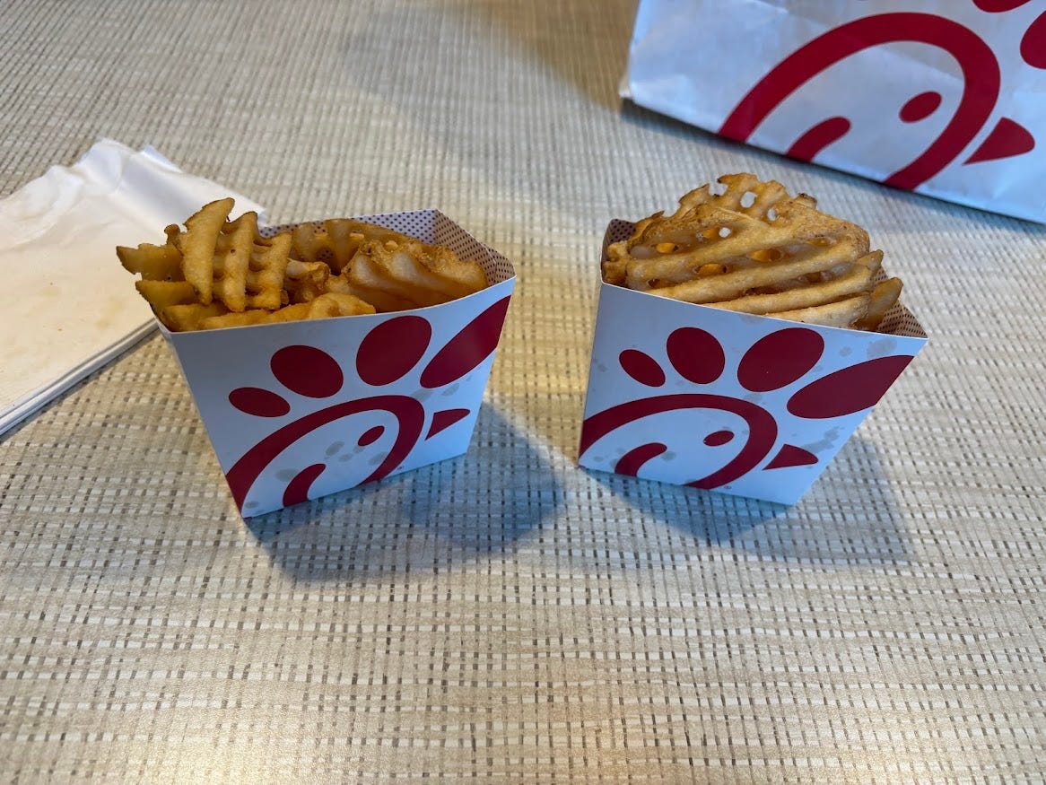 Two containers of waffles fries in containers with Chick-fil-A logo 