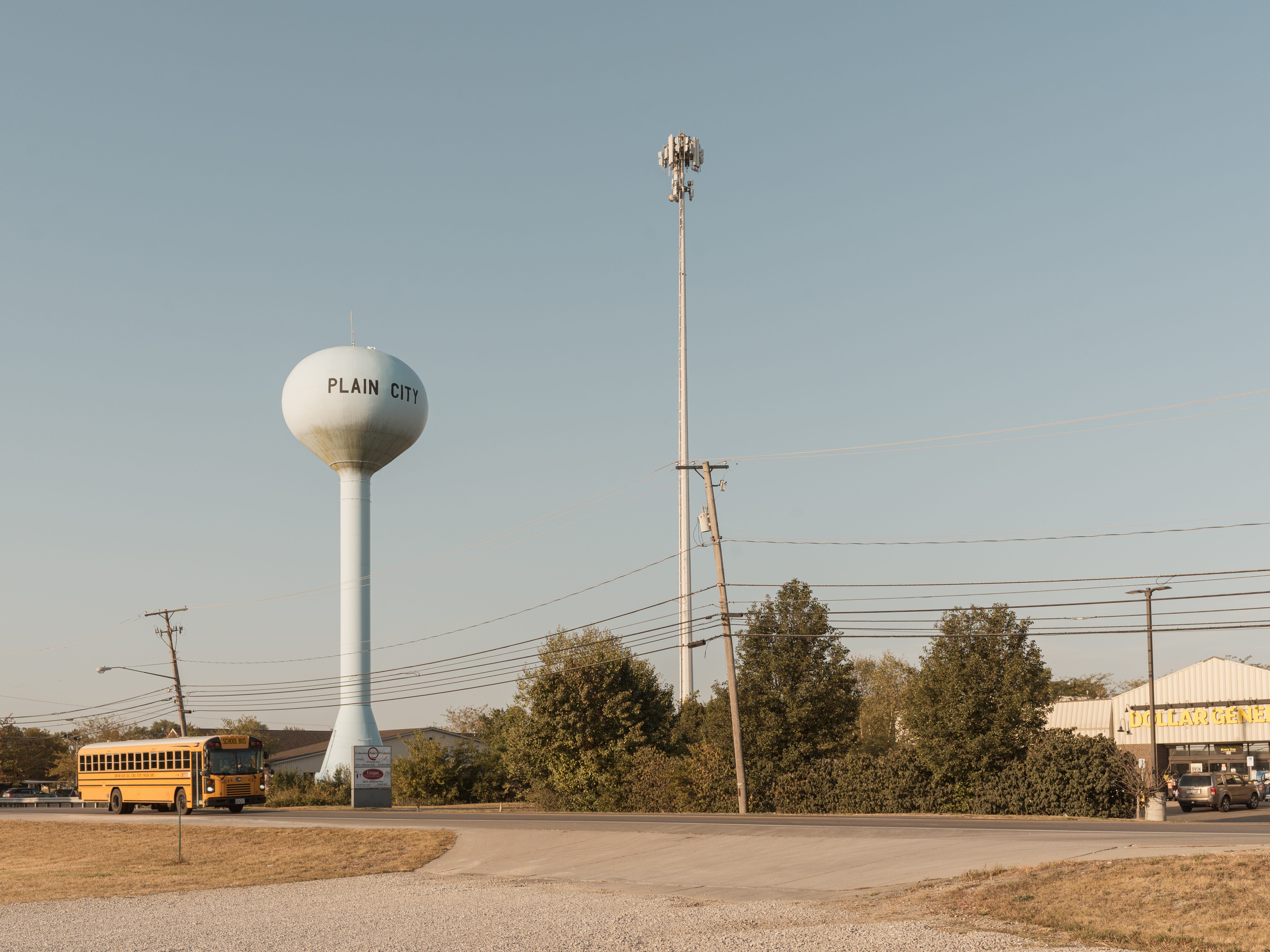 A school bus passes the Plain City water tower, Plain City, OH