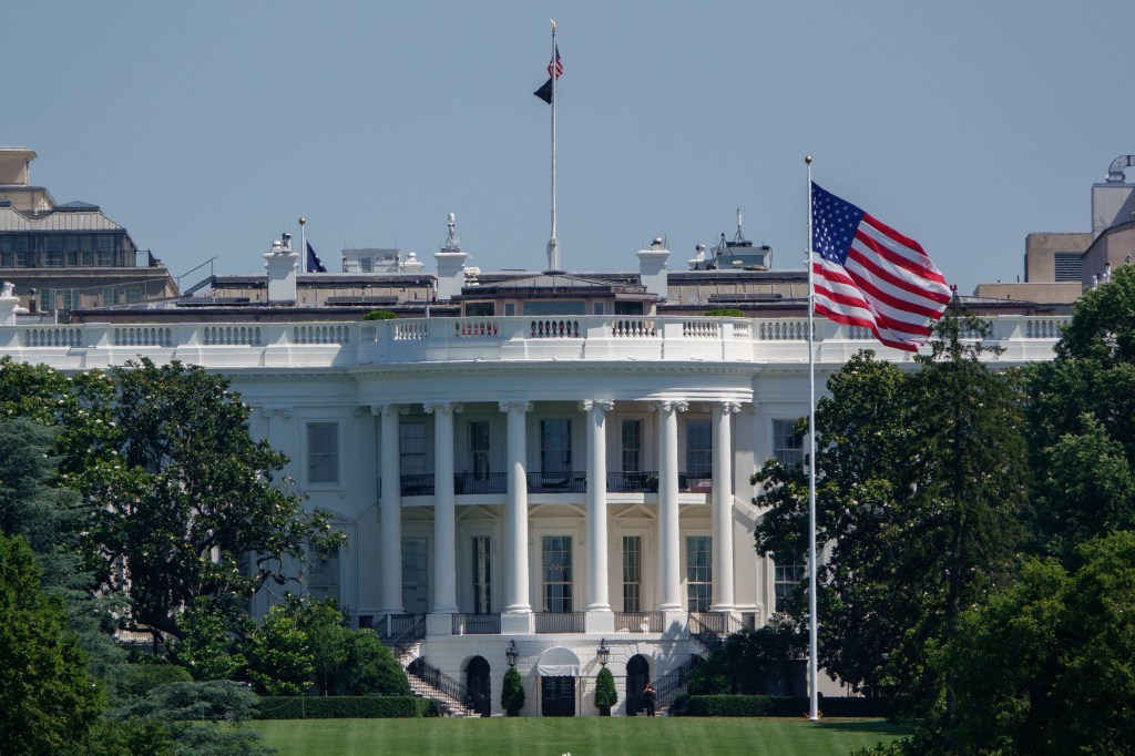 The White House with two flags flying.