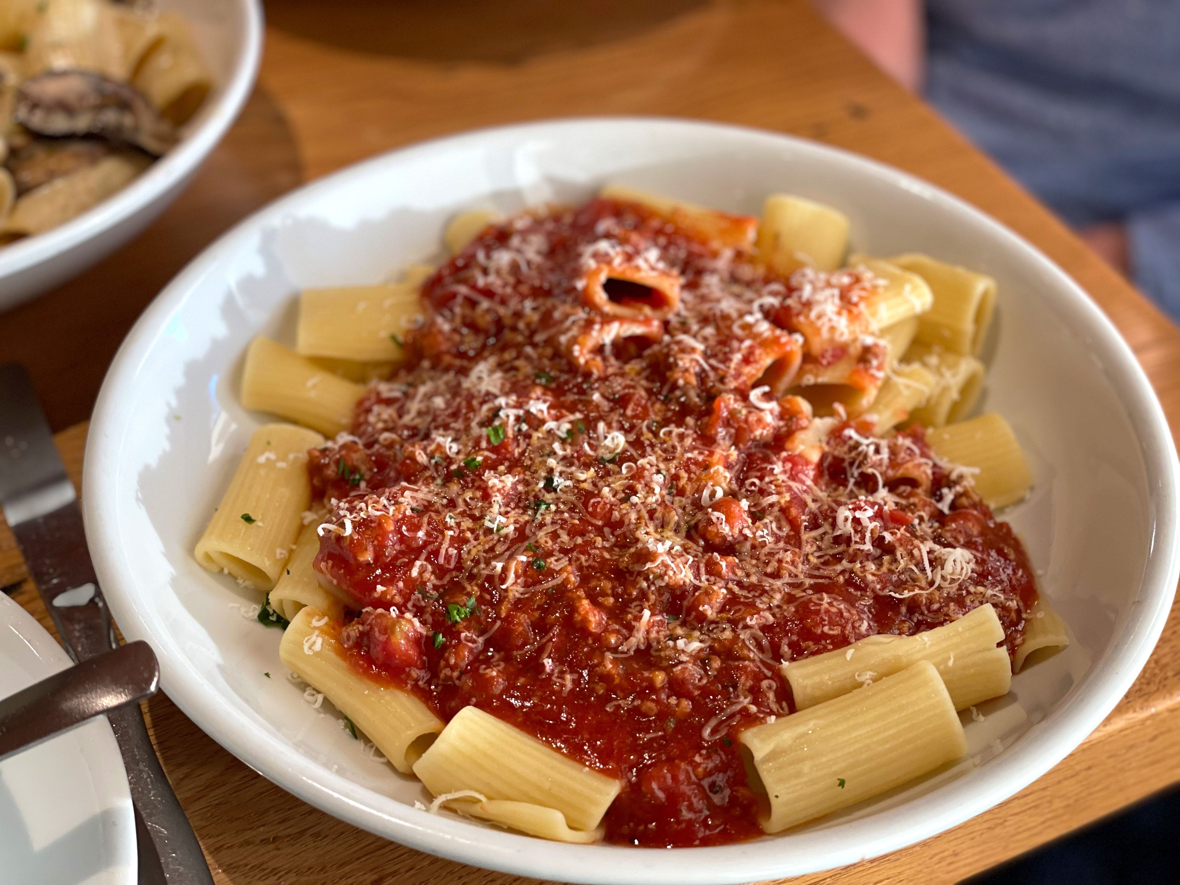 Rigatoni topped with a red meat sauce and Parmesan cheese.