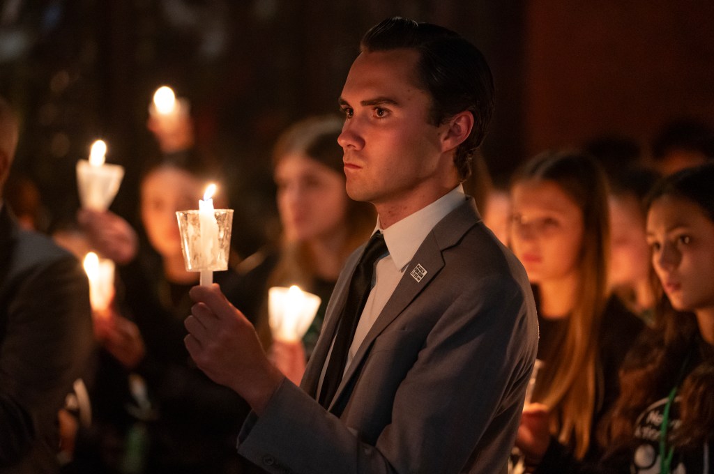 A man holds a candle at a vigil for victims of gun violence.
