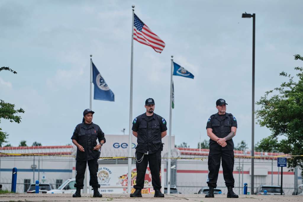 Three guards stand outside the La Salle Detention Facility in Jena, Louisiana.