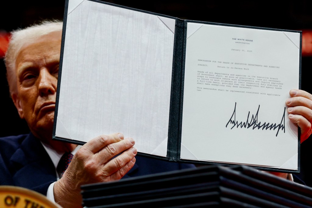 President Donald Trump signs an executive order on federal remote work during a signing ceremony inside Capitol One Arena on Jan. 20, 2025.