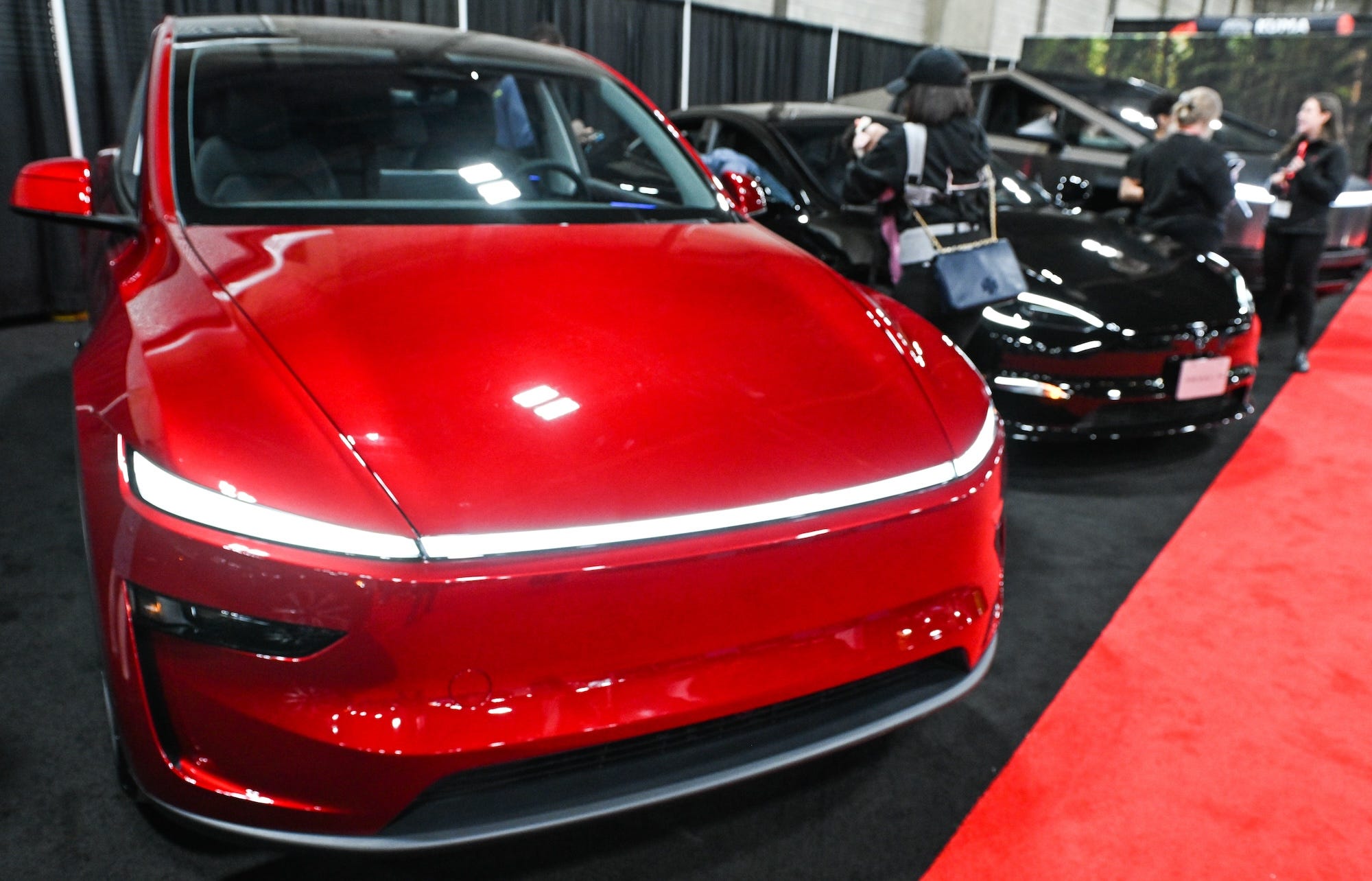 A red Tesla Model Y is on display in a showroom.