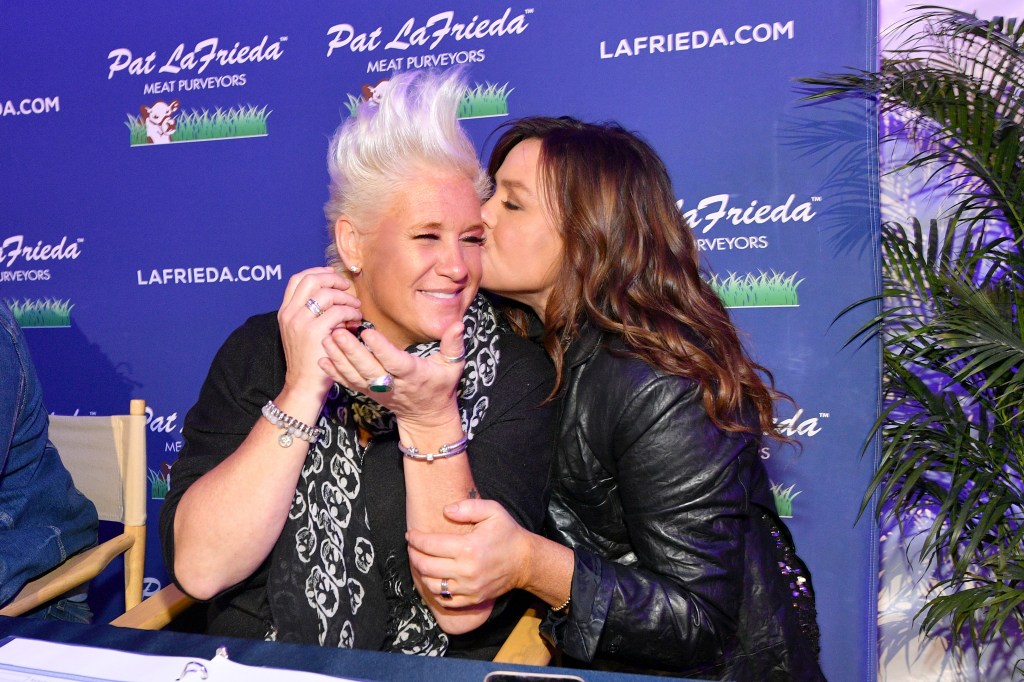Rachael Ray kissing Anne Burrell on the cheek at a foot event.