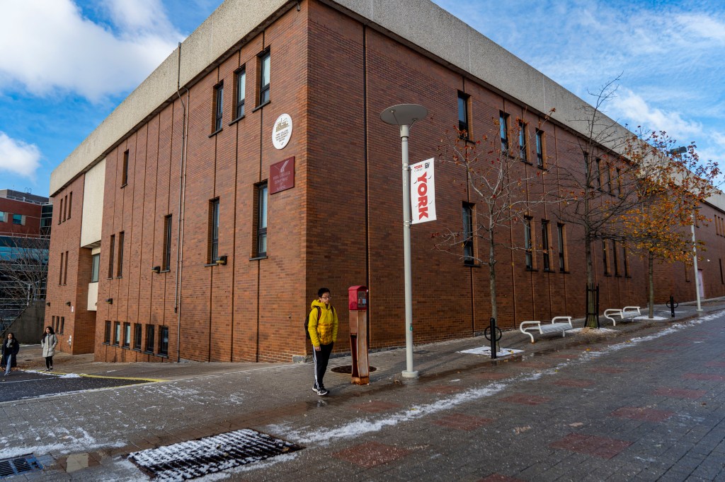 Student standing outside York College Department of Nursing building