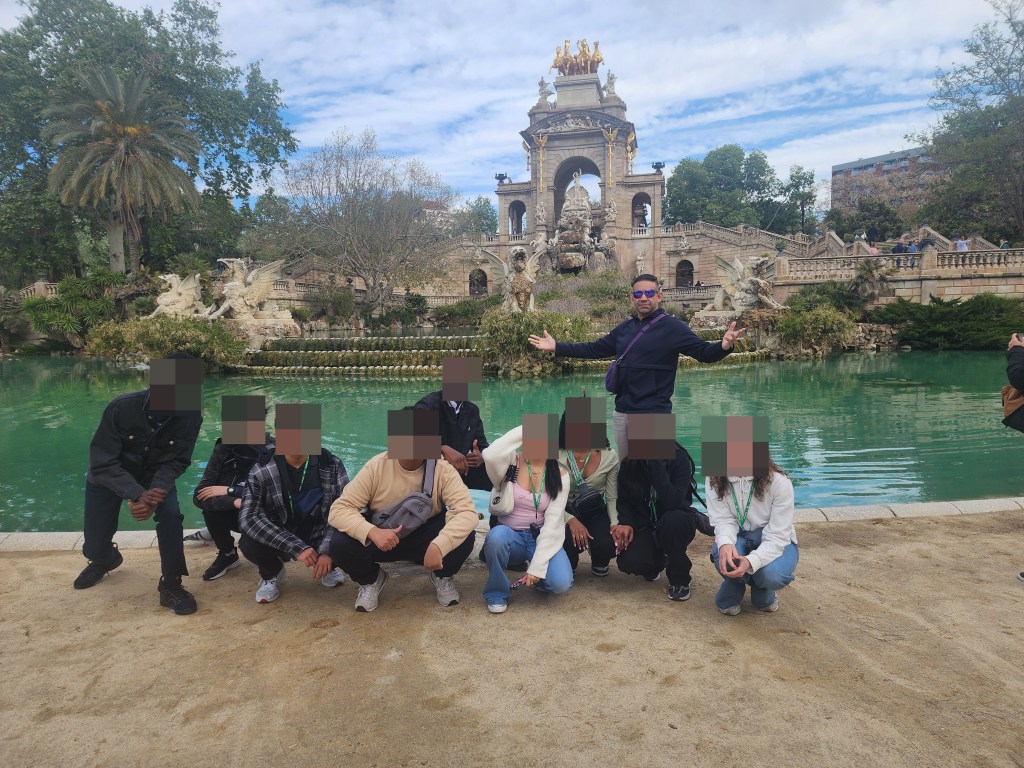 Group photo of Hector Diaz with students students from QHHS in Spain in front of a fountain.