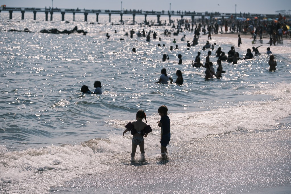 Two children playing in the ocean waves at Coney Island.  
