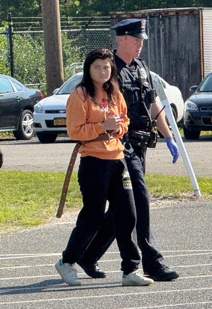 amanda kempton being walked into court orange sweatshirt black slacks hands cuffed in front of her