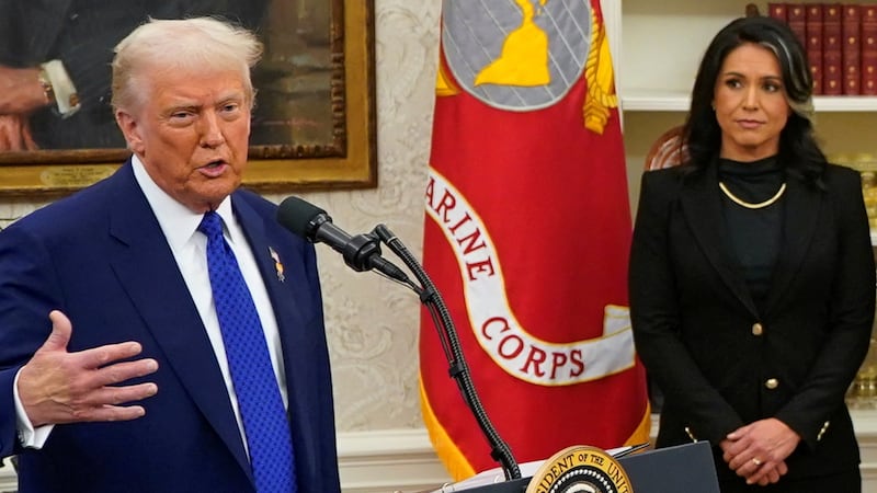 U.S. President Donald Trump speaks as Director of National Intelligence Tulsi Gabbard and her husband Abraham Williams stand by, on the day of Gabbard's swearing in ceremony in the Oval Office at the White House in Washington, D.C., U.S., February 12, 2025. REUTERS/Nathan Howard