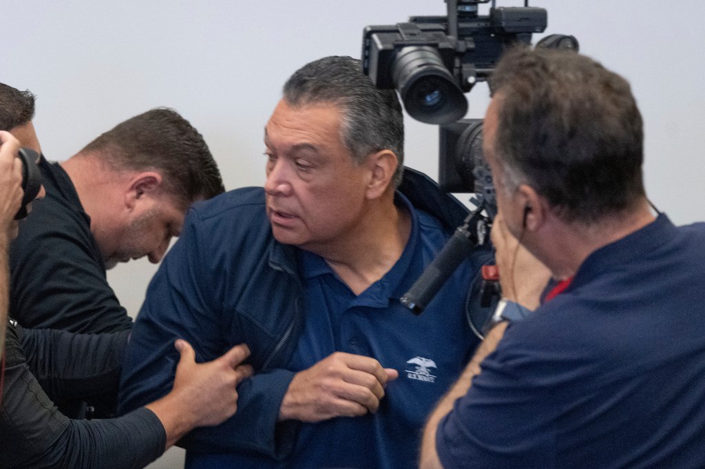 Sen. Alex Padilla being pushed by security personnel.