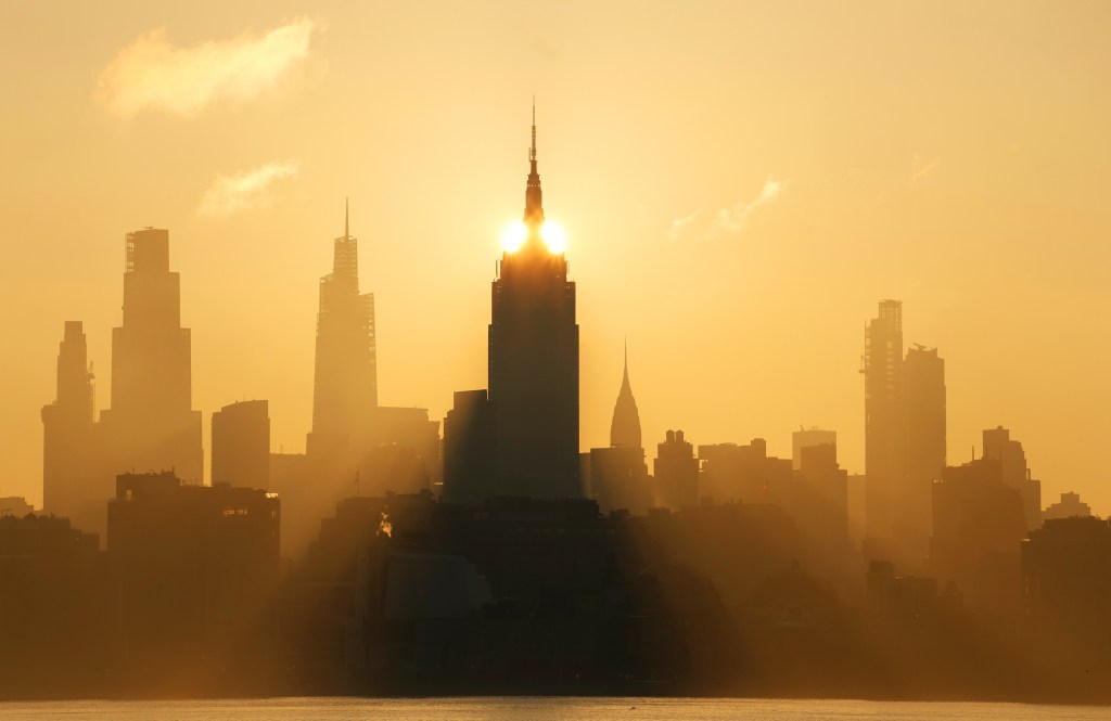 Sunrise behind the New York City skyline.