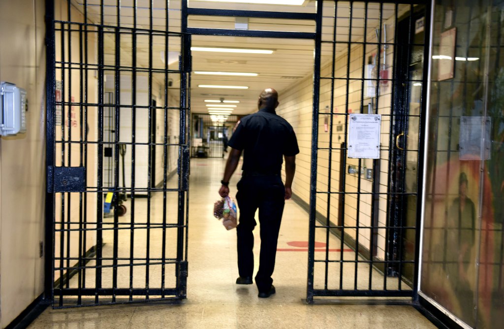 A corrections officer walks down a corridor inside Rikers Island.