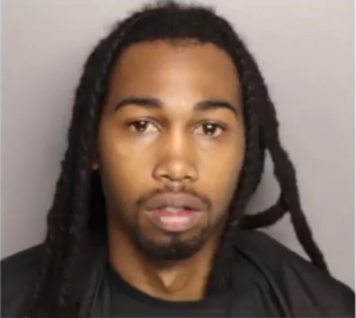 Mugshot of a man with long dreadlocks.