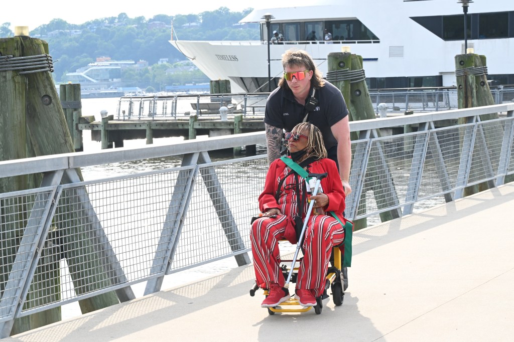 An injured passenger getting taken of the boat in a wheelchair.