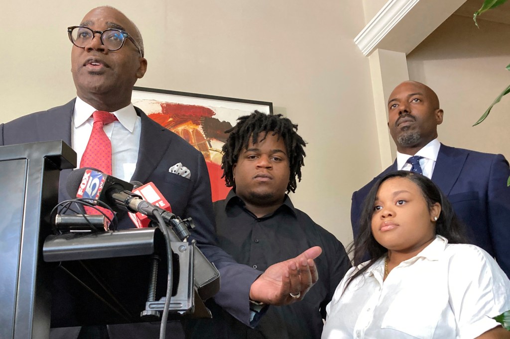 Photo of four people at a press conference announcing a lawsuit.