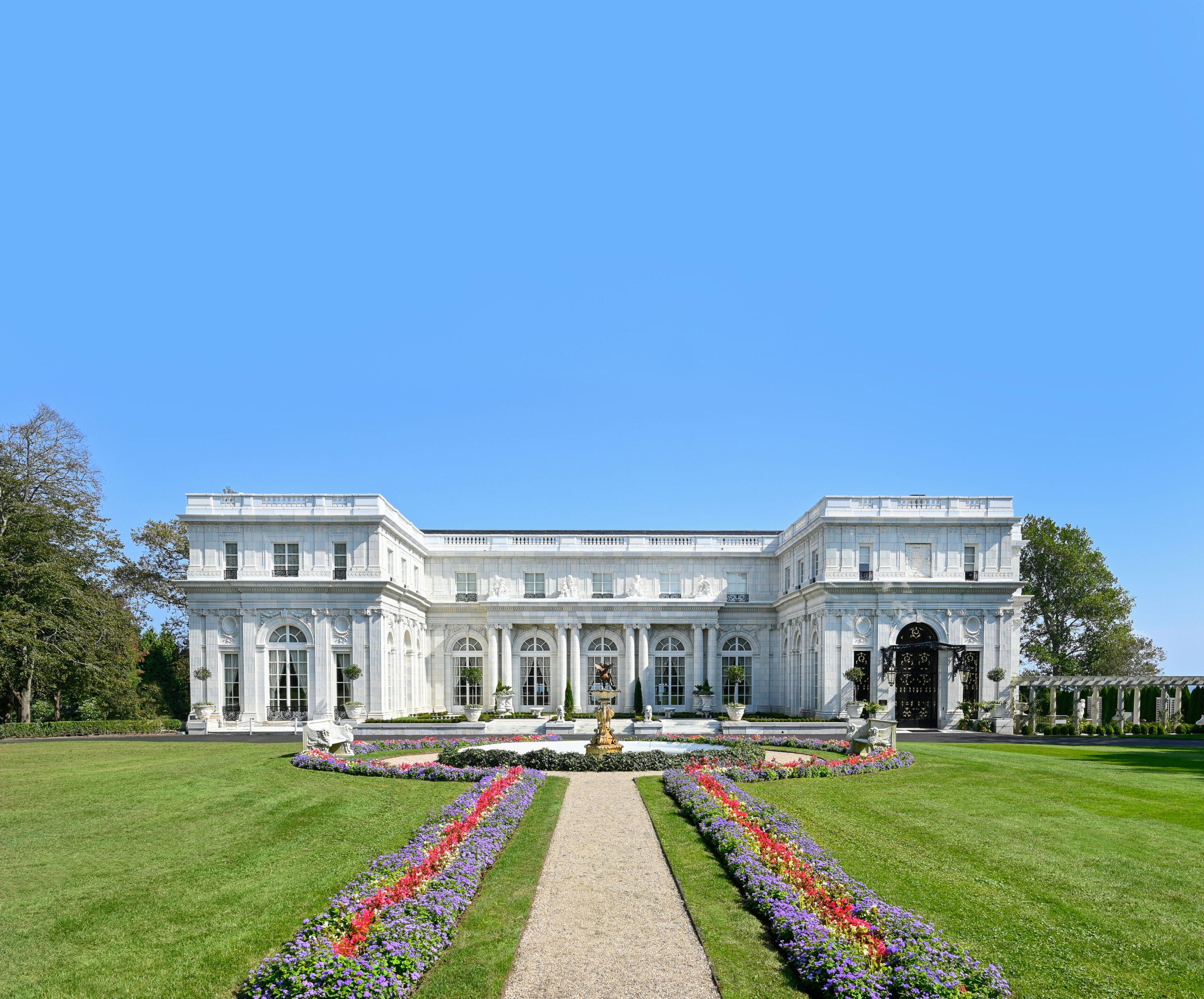 Rosecliff. A giant white mansion with flowers in the front.