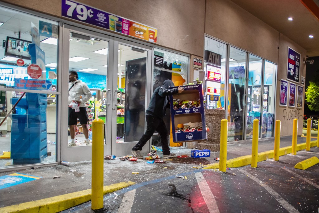 A looter steals from a gas station in Compton.