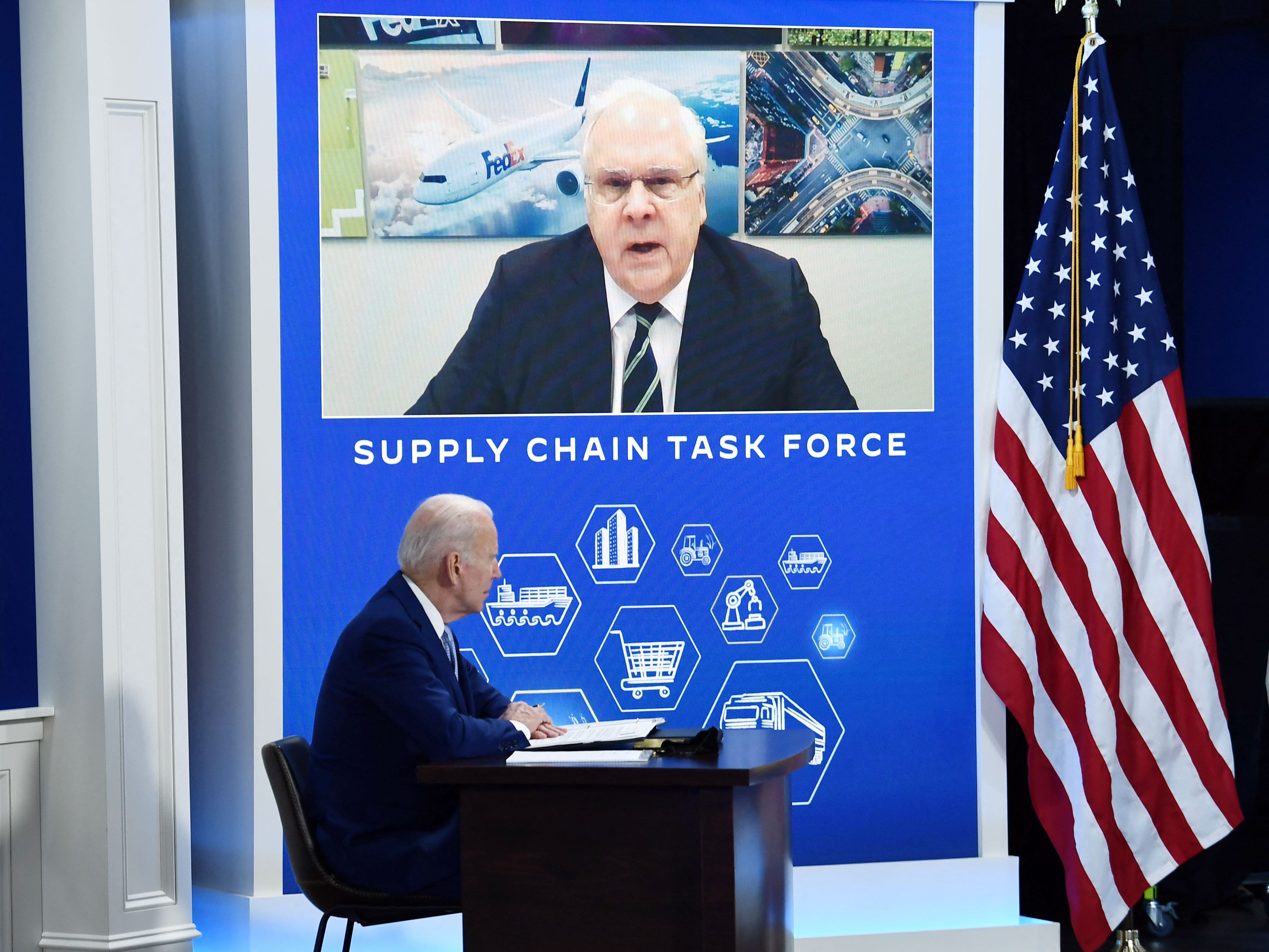 US President Joe Biden listens to FedEx CEO Fred Smith (on screen) during a meeting with the Supply Chain Disruptions Task Force and private sector CEOs, in the South Auditorium of the White House in Washington, DC, on December 22, 2021.