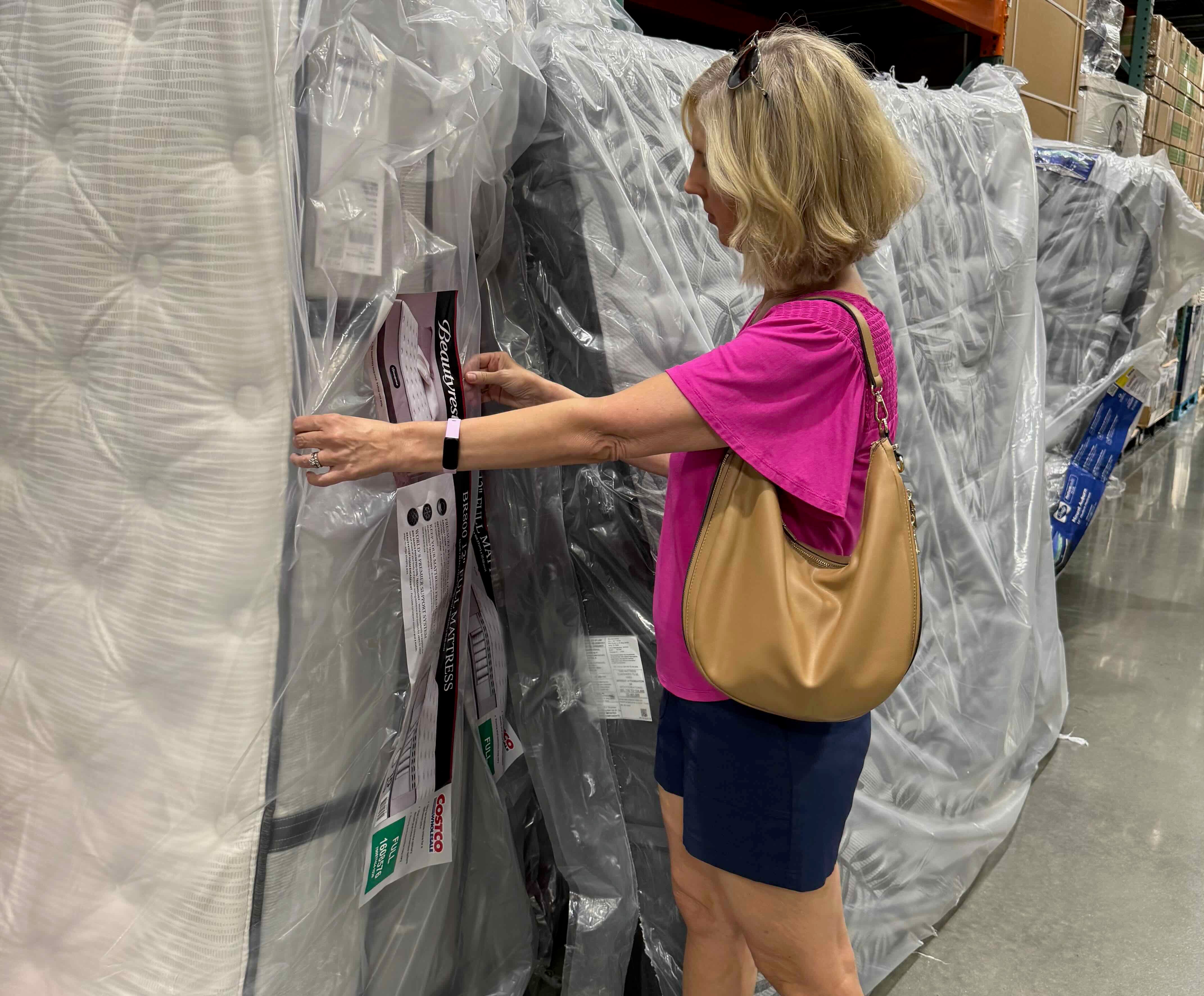 Woman looking at Costco mattresses