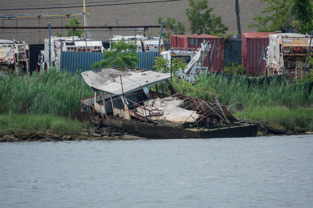 An abandoned boat sits on the shore of Westchester Creek.
