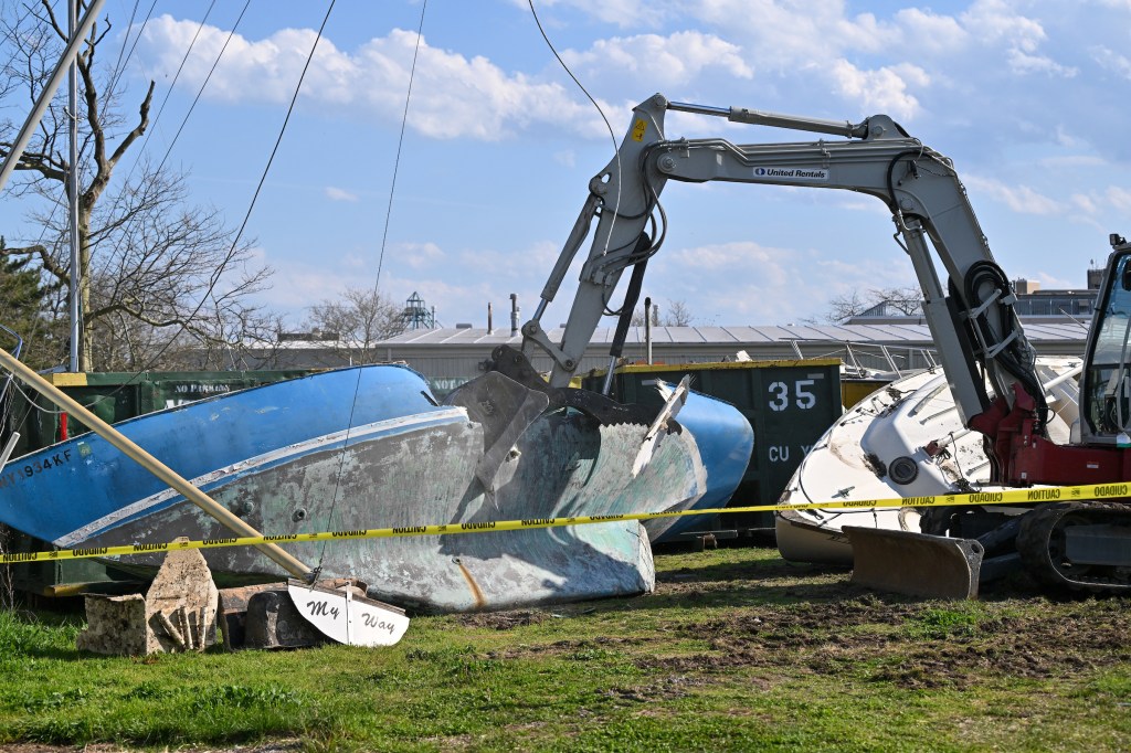 Excavator removing abandoned boats from NYC waterways.