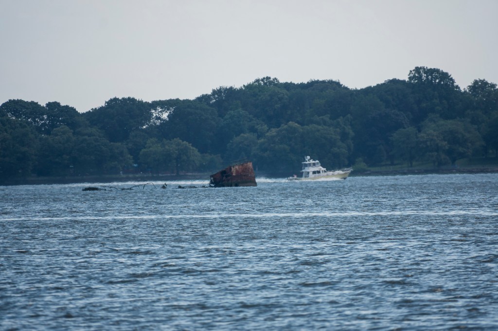 Boat passing a shipwreck.