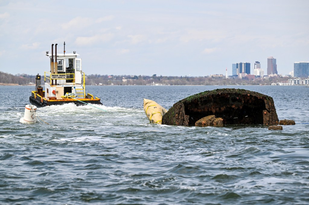 Tugboat towing a submerged wreck.