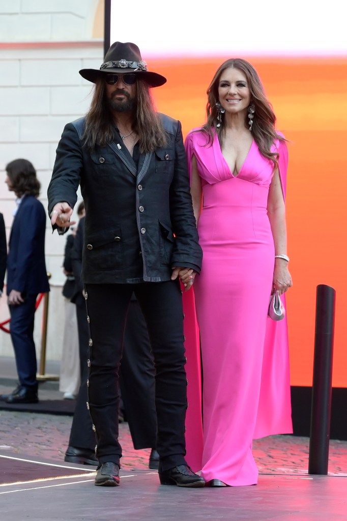 Elizabeth Hurley and Billy Ray Cyrus holding hands in 2025